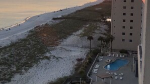 Un complexe hôtelier doté d’une piscine, d’un accès à la plage et offrant une vue sur le coucher de soleil sur l’océan.