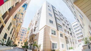 Un immeuble résidentiel à plusieurs étages, doté de balcons, d’une cour intérieure et d’une architecture moderne.