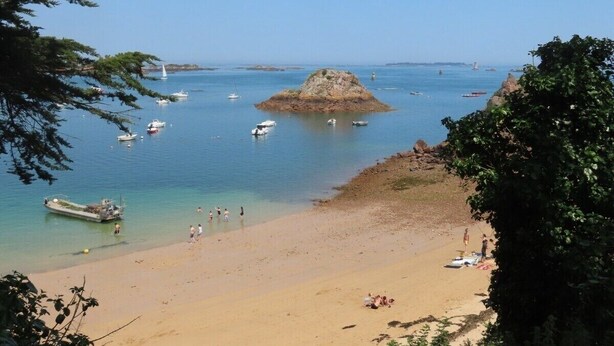 A beach with boats, a small rocky island, and clear blue water. - Charming House on Loguivy de la Mer harbor (Ploubazlanec)