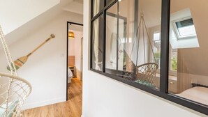 A room with a large window, a hammock chair, and a view of the outdoors. - Charming House on Loguivy de la Mer harbor (Ploubazlanec)
