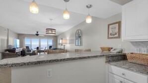A spacious kitchen with granite countertops, white cabinetry, and pendant lighting. - Sandy Key 433: 2 BR / 2BA Gulf Front Condo In Perdido Key, FL. Sleeps 6 (Pensacola)