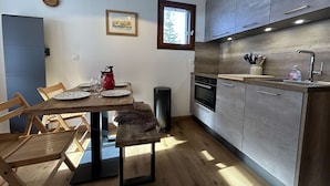 A modern kitchen with wooden cabinets, a built-in oven, and a window above the sink.