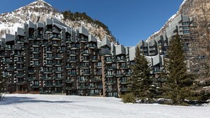 A modern hotel with multiple balconies, set against a snowy mountain backdrop. - Charming apartment with wifi, ski-in/ski-out in Val-d'Isère (Val-d'Isère)