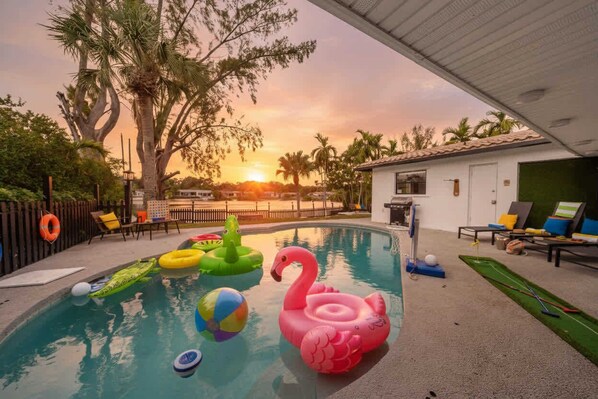 A swimming pool with inflatable toys and a sunset view. - Miami Lakefront 5BR Pool | Near Beach | Sleeps 14 (Miami)