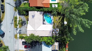 An aerial view of a house with a swimming pool, a garage, and a driveway. - Miami Lakefront 5BR Pool | Near Beach | Sleeps 14 (Miami)
