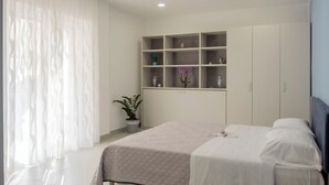 Une chambre à coucher moderne avec un lit, des tables de chevet, une armoire et une plante en pot.