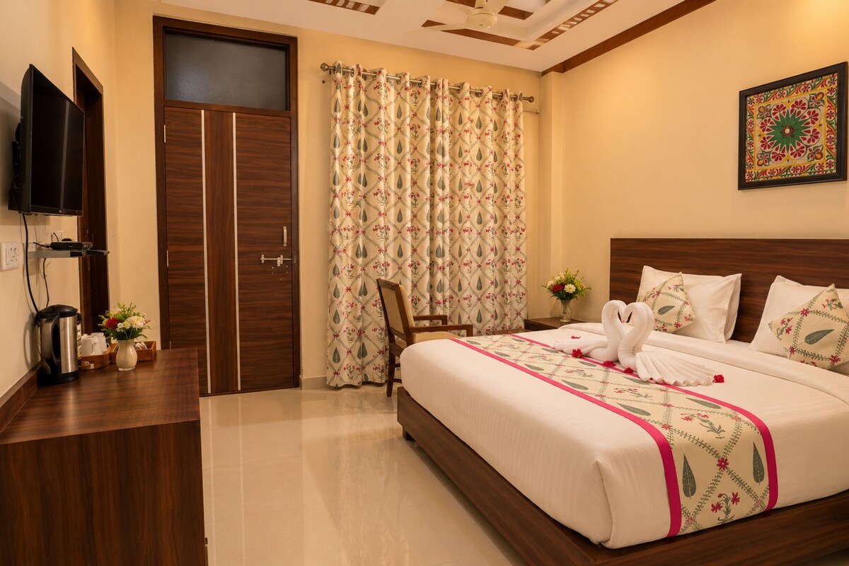 A hotel room with a bed, a television, a coffee maker, and a decorative wall piece.
