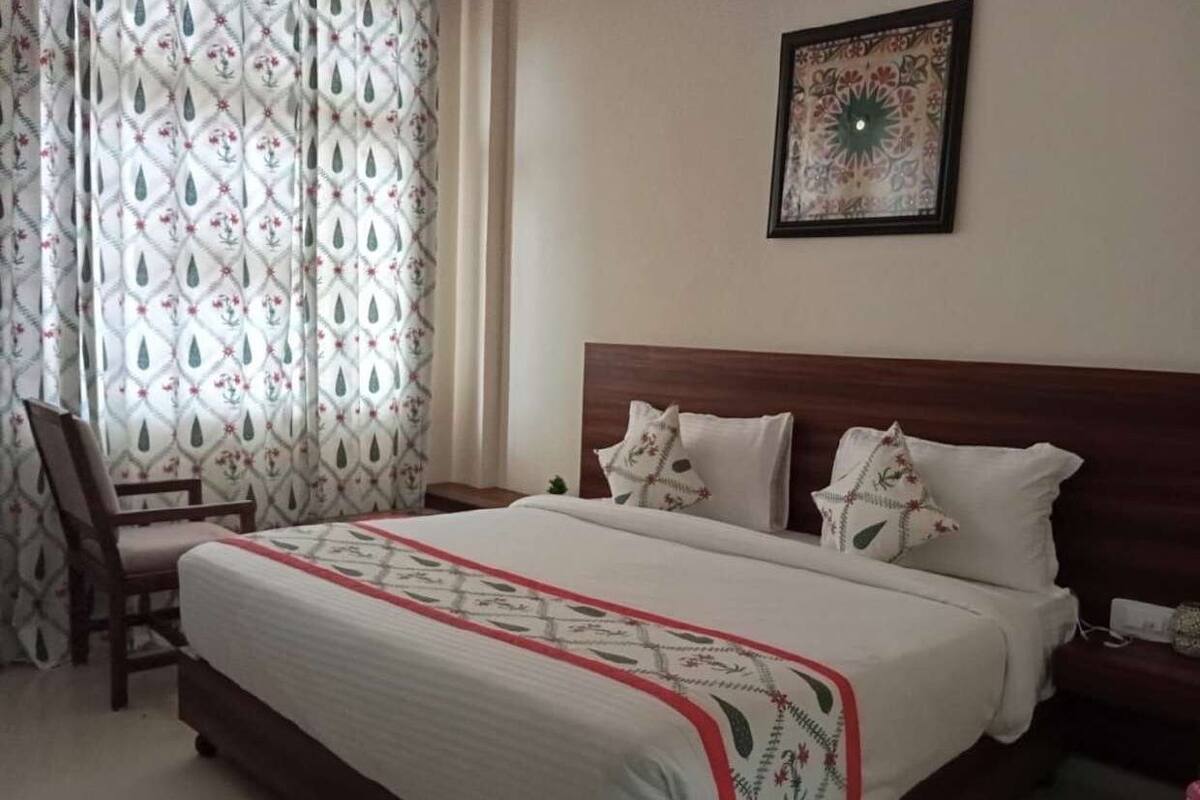 Ein Schlafzimmer mit einem großen Bett, einem hölzernen Kopfteil und einem Sessel.