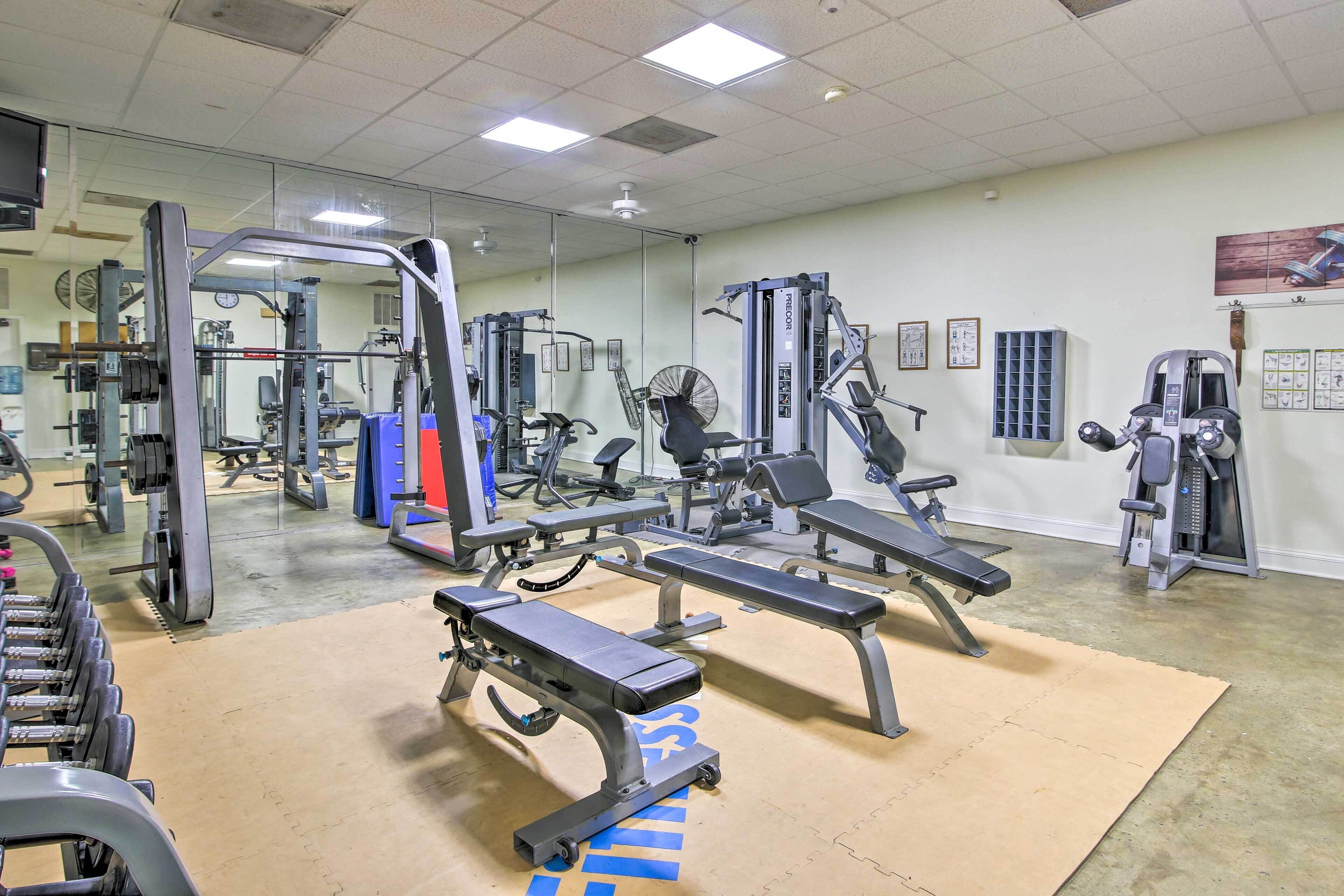 A gym with various exercise equipment, including benches and weight machines.