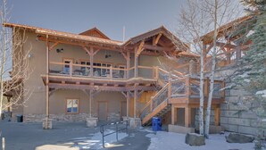 Eine mehrstöckige Lodge mit einer Stein-Fassade, hölzernen Balkonen und einer Seilbahn im Hintergrund.