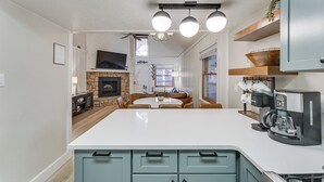 Eine moderne Küche mit Kochinsel, integrierten Geräten und einem Essbereich mit Kamin.