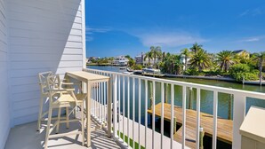 A balcony with a view of a marina and palm trees. - Walk to Beach! Waterfront Hudson Townhome (Hudson)
