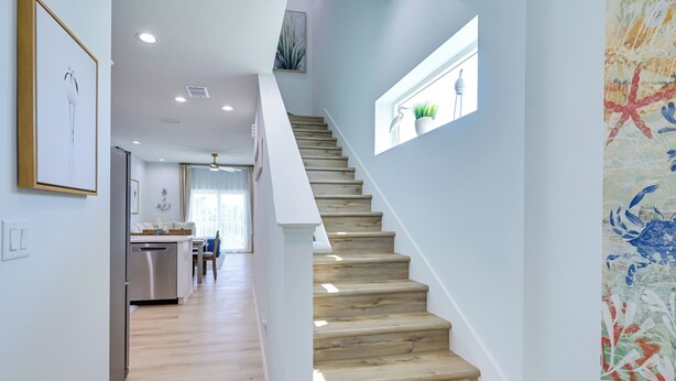 A staircase with wooden steps leading to a landing. - Walk to Beach! Waterfront Hudson Townhome (Hudson)