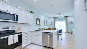 A modern kitchen with white cabinetry, stainless steel appliances, and a central island. - Walk to Beach! Waterfront Hudson Townhome (Hudson)