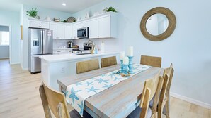 A modern kitchen with white cabinets, stainless steel appliances, and a central island. - Walk to Beach! Waterfront Hudson Townhome (Hudson)