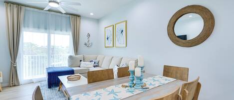 A dining area with a wooden table, chairs, and a ceiling fan.