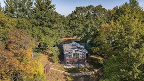 A house surrounded by dense forest, with a clear view of the property and its surroundings. - Private 3BR Lakefront | Firepit + Kayaks | Near WI Dells (Oxford)