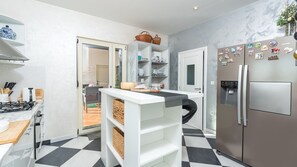 A modern kitchen with a checkered floor, white cabinetry, a built-in stove, and a stainless steel refrigerator. - Villa Sv. Anna by Villas Guide (Radetici)