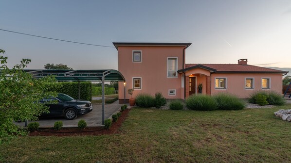 A two-story house with a car parked in the driveway.