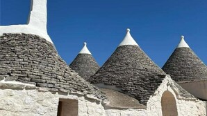 A building with a stone facade and multiple conical roofs. - A Trullo Like No Other - Timeless Style, Modern Comforts. Private Pool (Selva di Fasano)