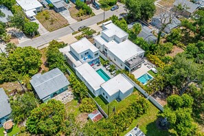 An aerial view of a residential area with multiple houses, a swimming pool, and lush greenery. - Paradise Found 3 Bedroom Home by RedAwning (Sarasota)