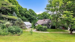 A residential property with a house, a shed, and a well-maintained lawn. - Bear Pass - Mountain View 4 Bedroom Home by RedAwning (Arlington)