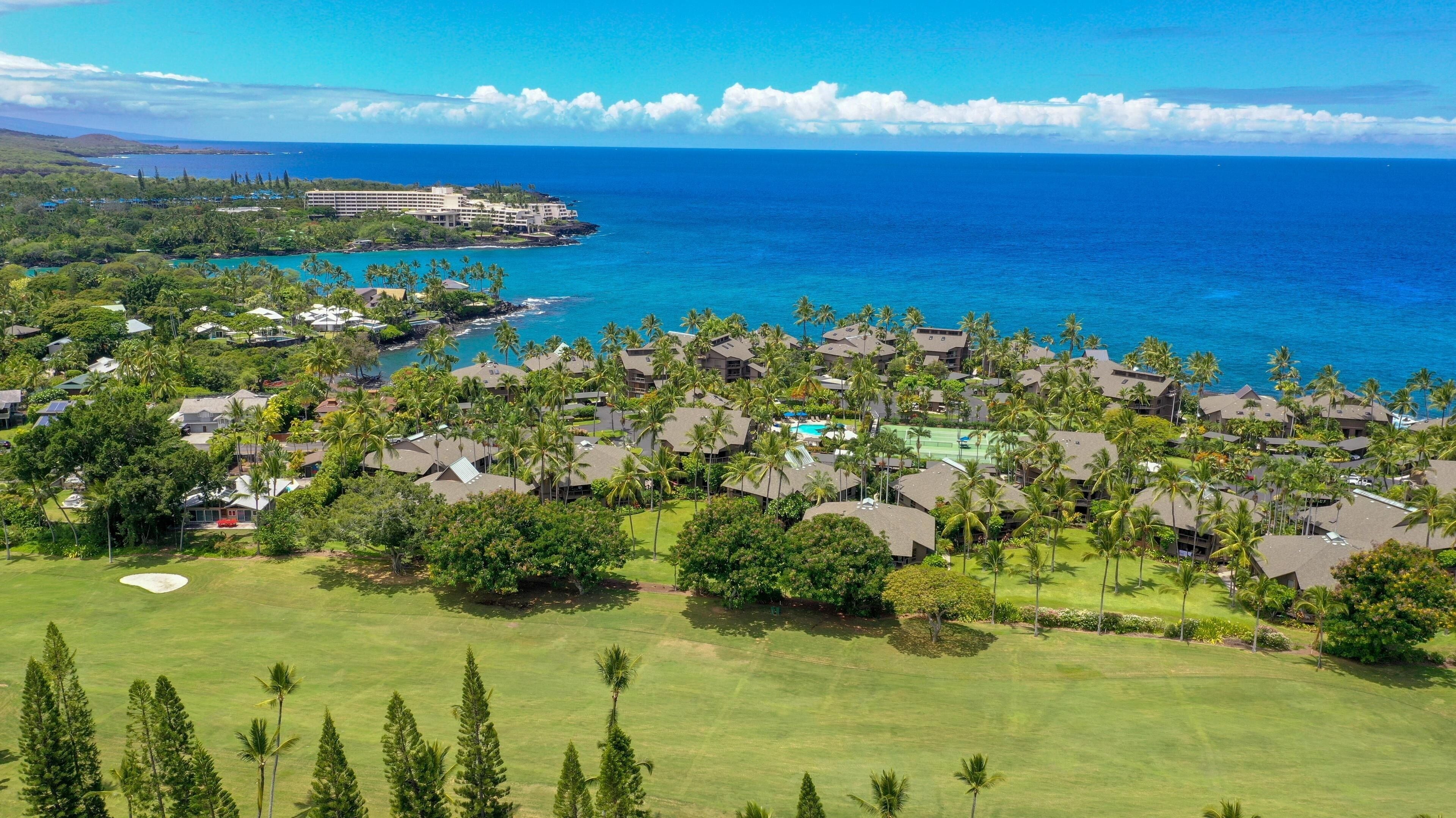 A coastal resort with multiple buildings, a golf course, and a view of the ocean.