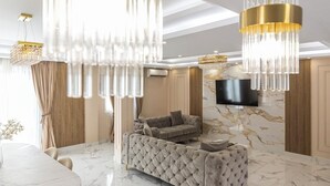 Een luxueuze woonkamer met een marmeren vloer, een gestofte bank en een grote kroonluchter.