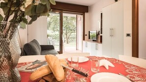 A dining area with a red tablecloth, a vase with green leaves, and a wooden cutting board with bread. - COSTA RICA BIBIONE Eco Resort (San Michele al Tagliamento)