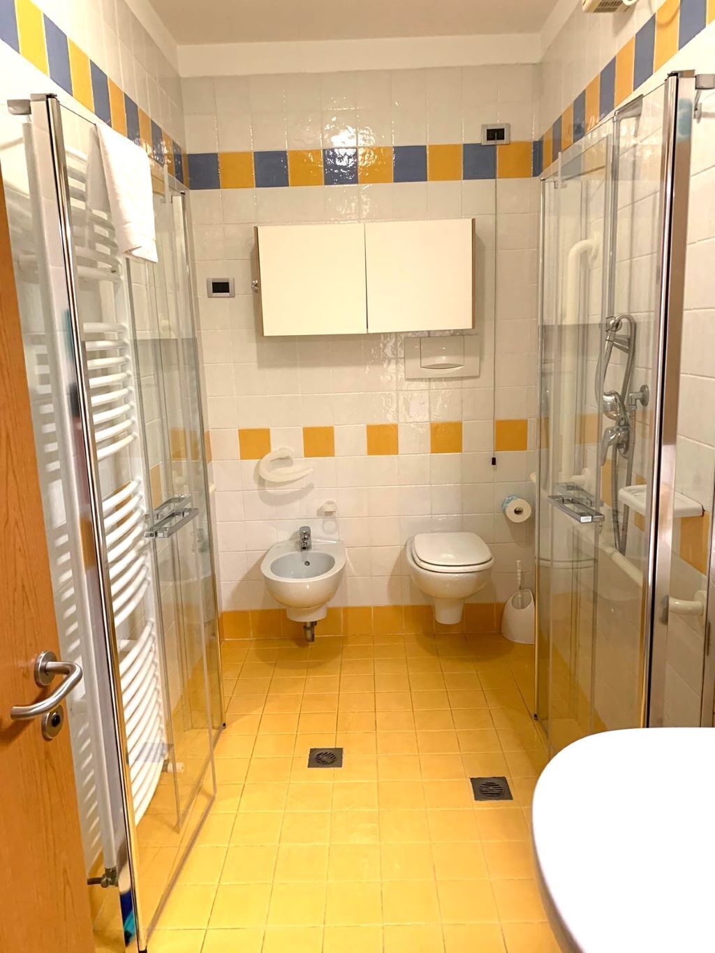 Une petite salle de bain équipée d’une douche, de toilettes, d’un bidet et d’un lavabo.