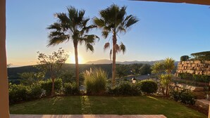 A patio with a view of palm trees and distant mountains. - Bright 3BR with Sunset Views and Garden (Benahavís)