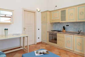 Een koelkast, een oven, een vaatwasser, kookgerei, borden en bestek