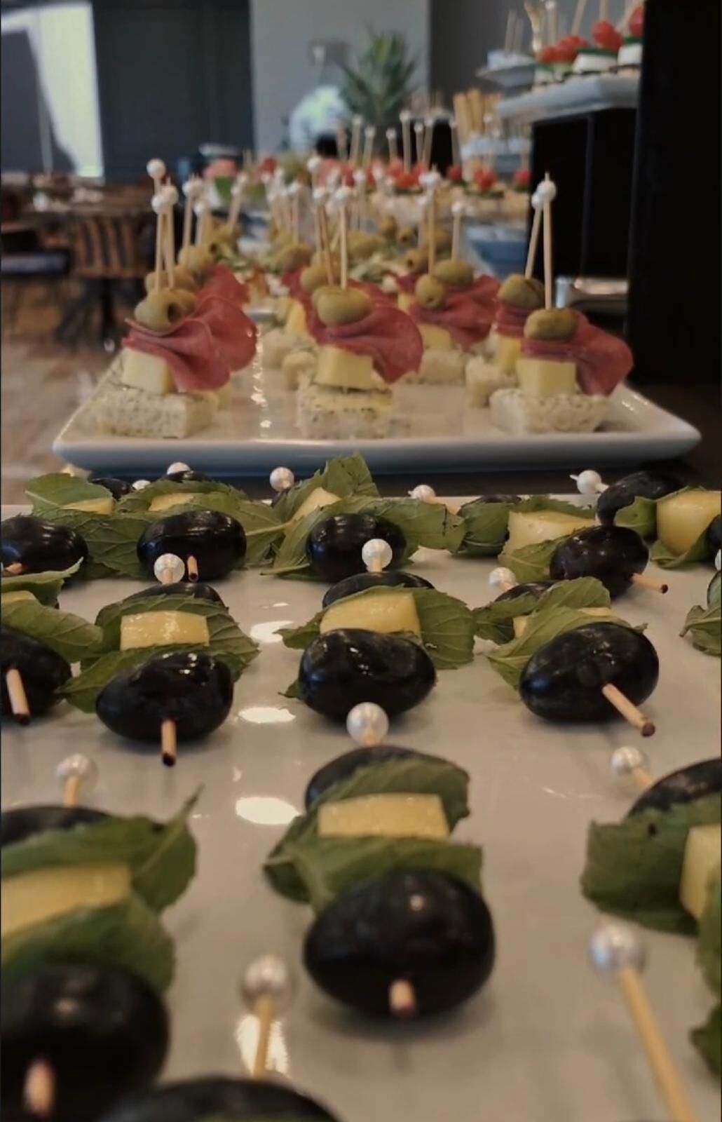 Ein reichhaltiges Buffet mit verschiedenen Vorspeisen, darunter Oliven am Spieß und Käsewürfel.