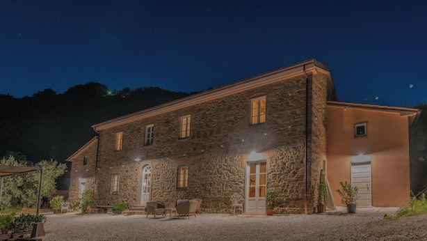 A stone building with a gravel driveway and outdoor seating area. - Typical Stone House with Swimming Pool 6/8 Pax in the countryside between Florence and Lucca. (marliana)