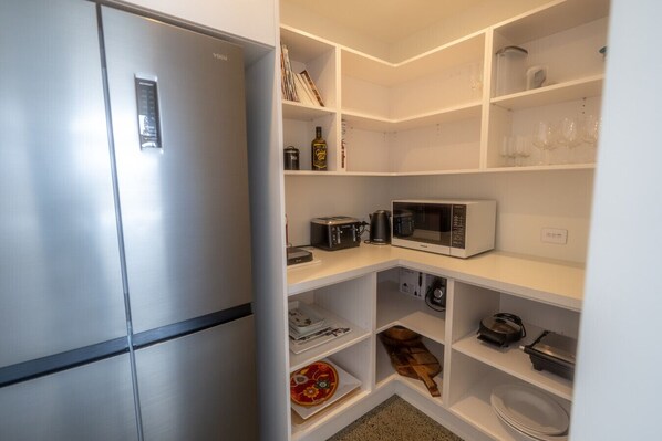 A compact kitchen with a refrigerator, microwave, and coffee maker. - Twizel House on Ben Ohau (Lake Ōhau)