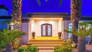 Una casa con facciata in pietra, una porta in legno scuro e un ingresso ben illuminato.