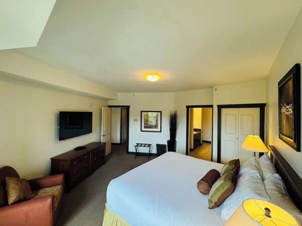 Une chambre d’hôtel avec un grand lit, une télévision, un bureau et une chaise.