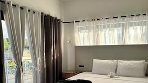 A modern bedroom with a large bed, a ceiling fan, and a view of the outdoors through sheer curtains. - Cozy hotel in enjoyable Kingston with AC, WiFi (Kingston)