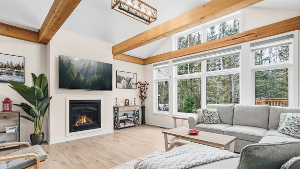 Una sala de estar con chimenea, ventanas amplias y un rincón de descanso acogedor.
