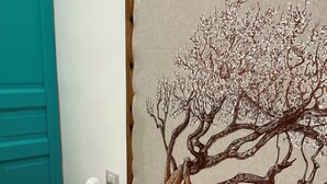 A bedroom with a bed, a nightstand, a wall-mounted lamp, and a door. - Suite Cavallotti - The Almond (Orvieto)