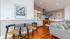 Un appartement moderne comprenant un coin repas, une cuisine et un salon.