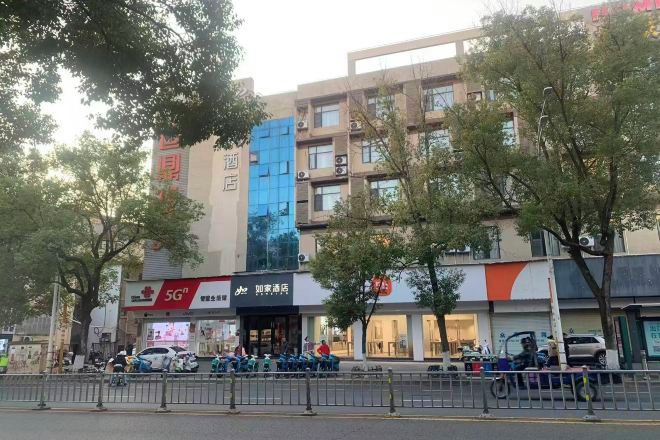 A multi-story building with a modern facade, featuring a prominent blue section and signage for a 5G service provider.