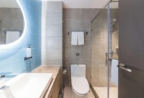 A modern bathroom with a bathtub, toilet, and glass shower enclosure. - Homeinn · neo (Fuzhou Wanxiang New City Tianmu Square) (Fuzhou)