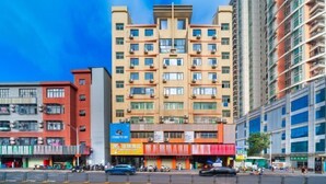 A multi-story hotel with a central atrium, multiple balconies, and a variety of ground-level shops.