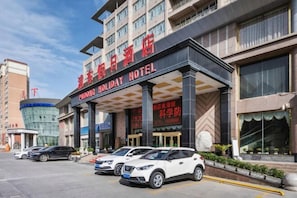 A hotel with a modern facade, multiple floors, and a prominent entrance.