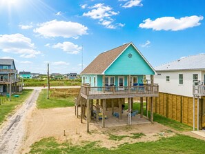 A coastal house with a balcony, a deck, and a view of the beach. - Beachfront Home | Direct Beach Access | Gulf Views | Large Deck | Pet Friendly (Gilchrist)
