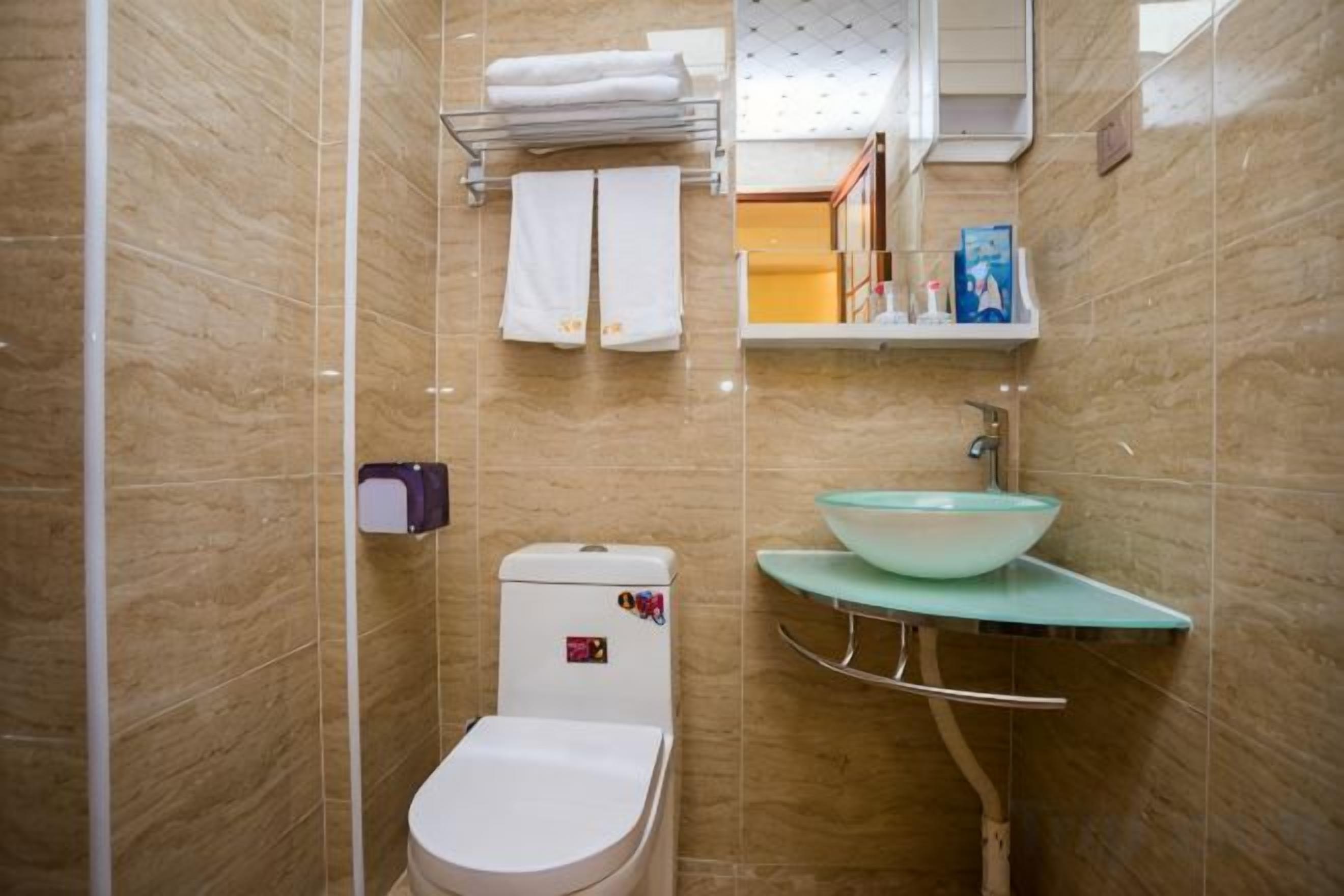 A bathroom with a toilet, sink, and towel rack.