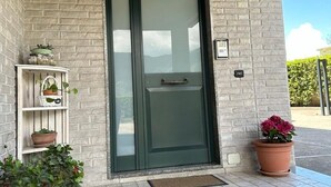 A door with a handle, a small shelf with potted plants, and a potted plant to the right. - Garden House B&B - Vesuvius - Cozy accommodation for couples and families (Striano)