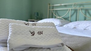 A neatly made bed with white linens and a metal headboard. - Garden House B&B - Vesuvius - Cozy accommodation for couples and families (Striano)