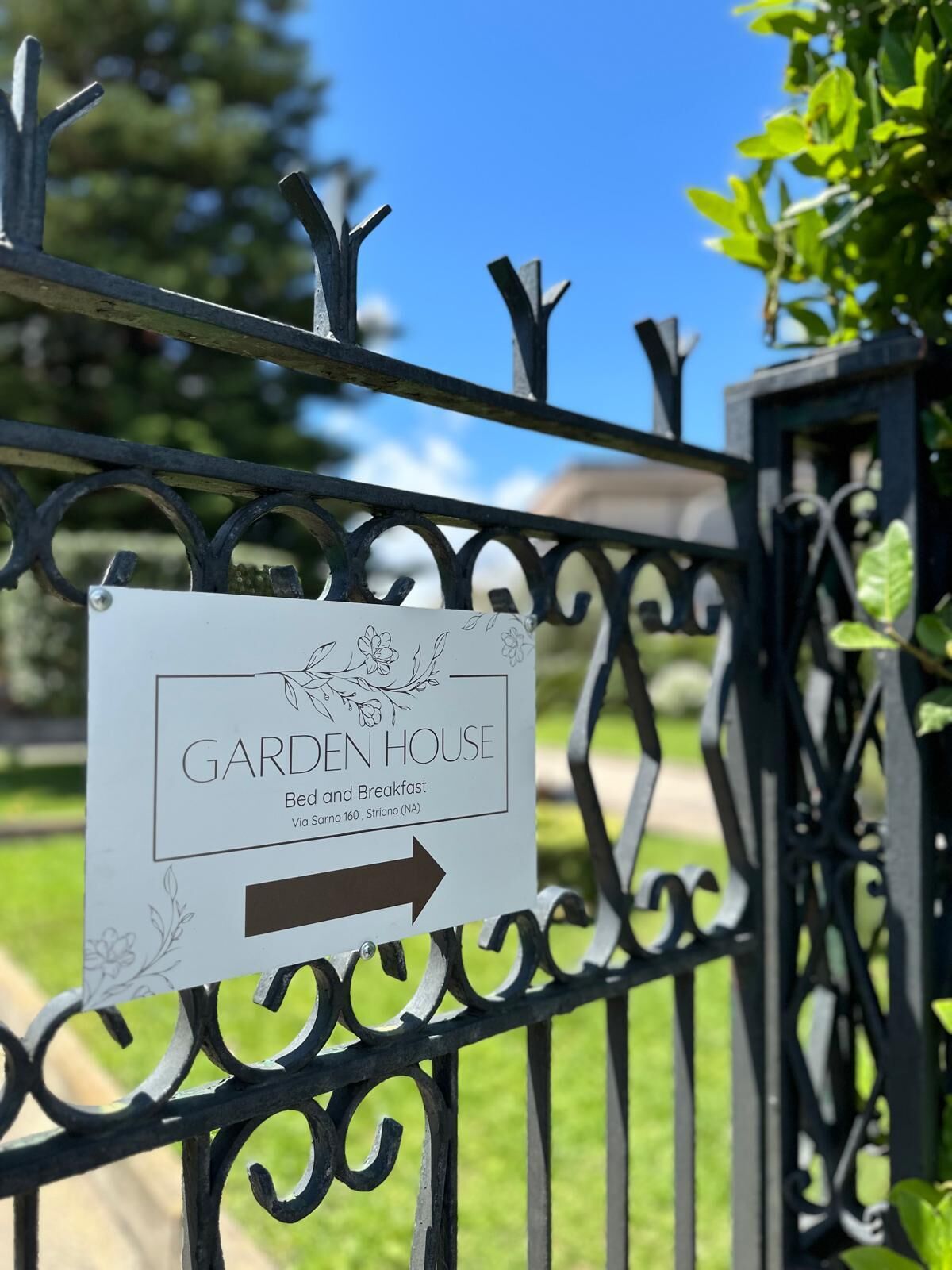 A sign for 'GARDEN HOUSE' indicating Bed and Breakfast services, located via Striano 160.